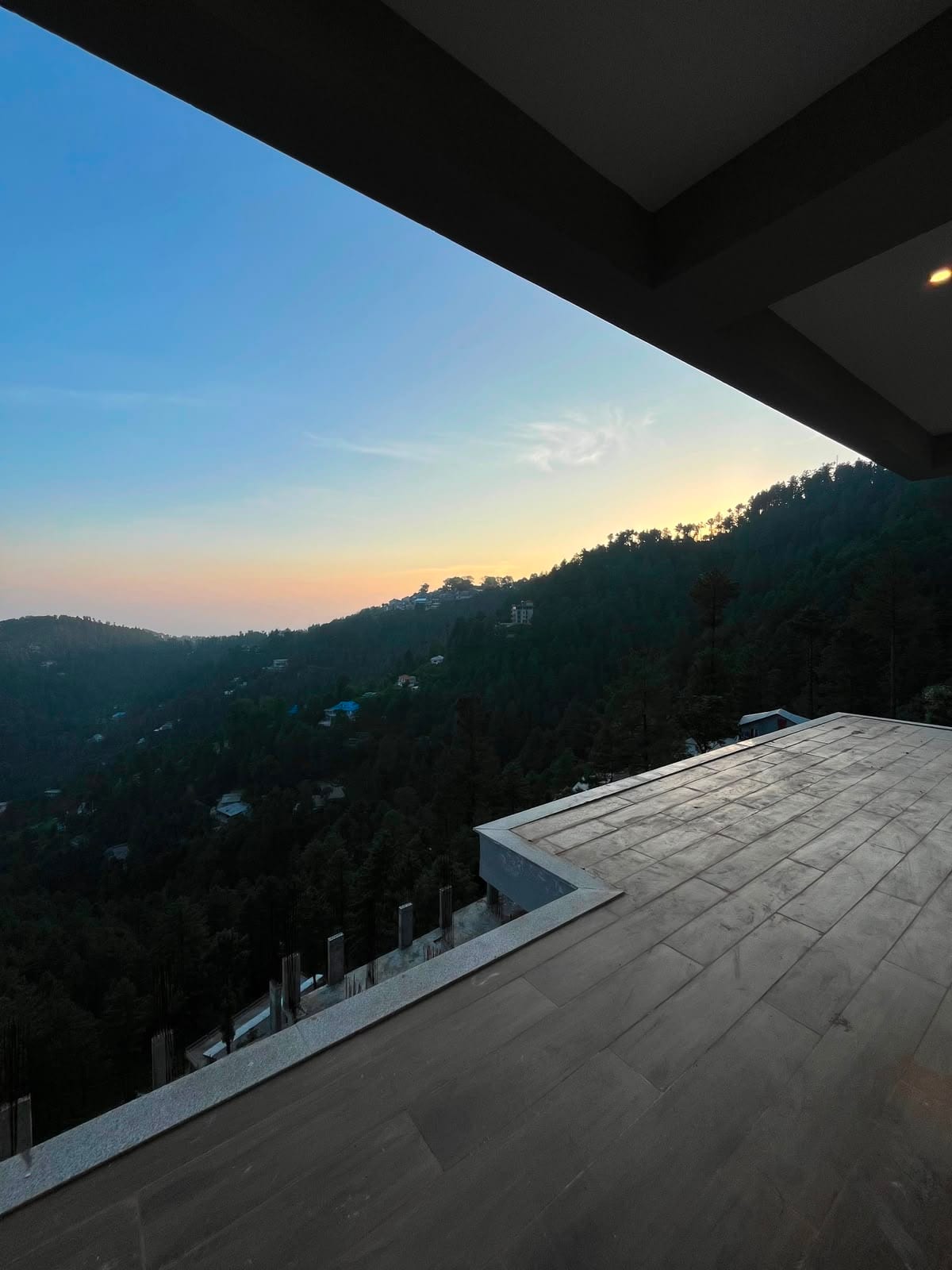 Sunset over the pine-covered Galiyat hills from an apartment terrace at MYG Nathiagali